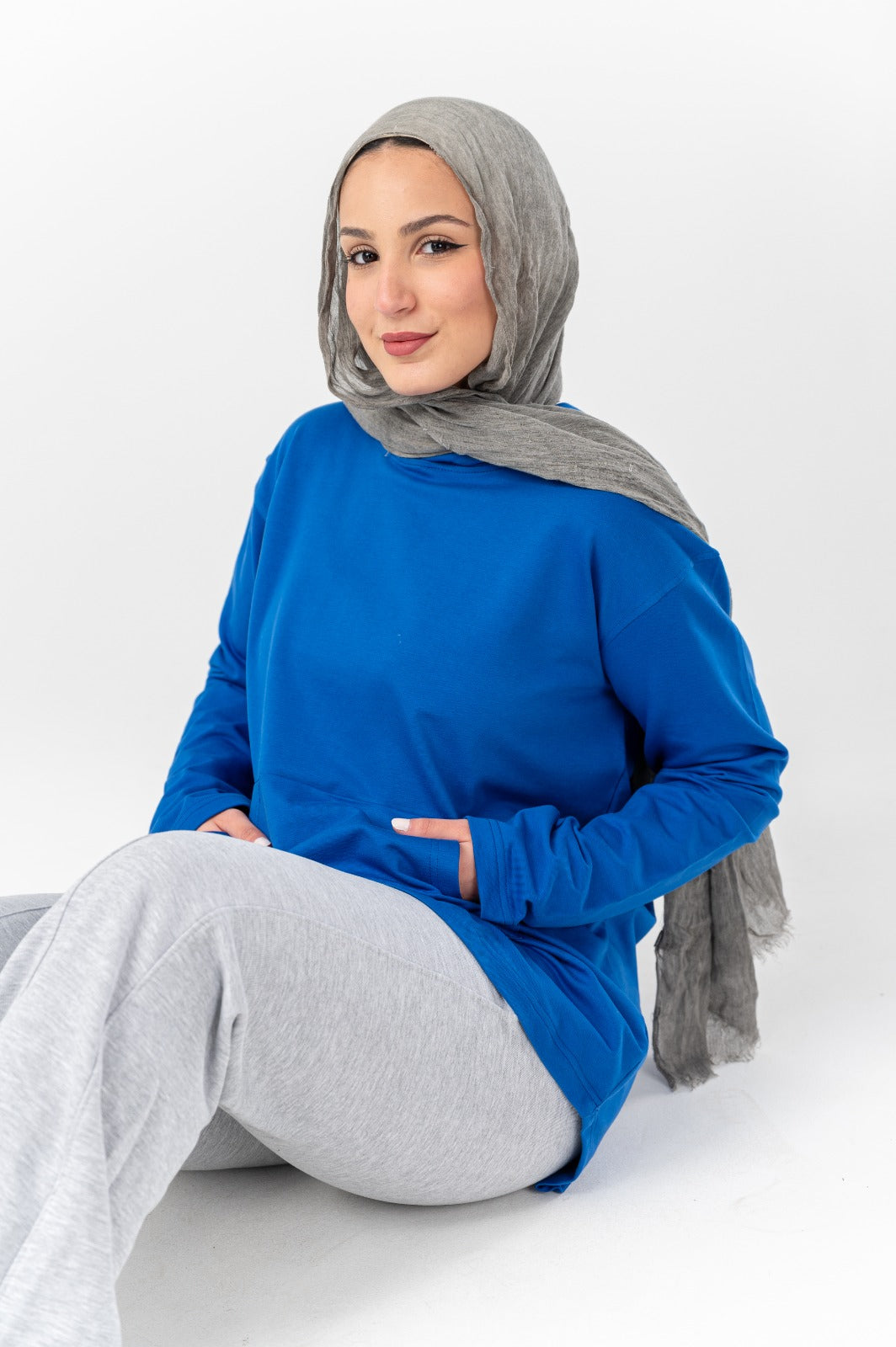 Blue hoodie by Akira with a relaxed fit, featuring a front pocket and drawstring hood, displayed on a plain background.