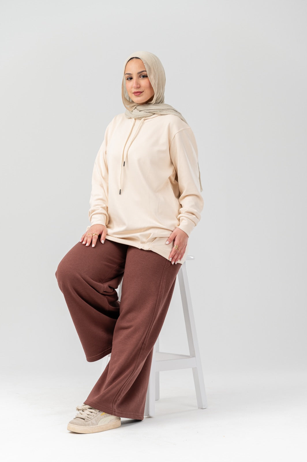 Beige comfort hoodie by Akira featuring a relaxed fit, soft fabric, and hood with drawstrings, displayed on a hanger.