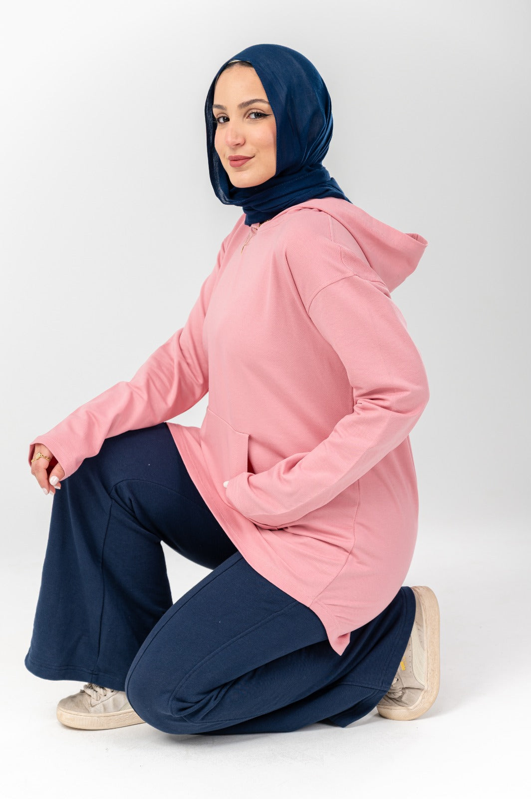 Pink hoodie by Akira featuring a relaxed fit, soft fabric, and a casual style, shown on a hanger against a plain background.