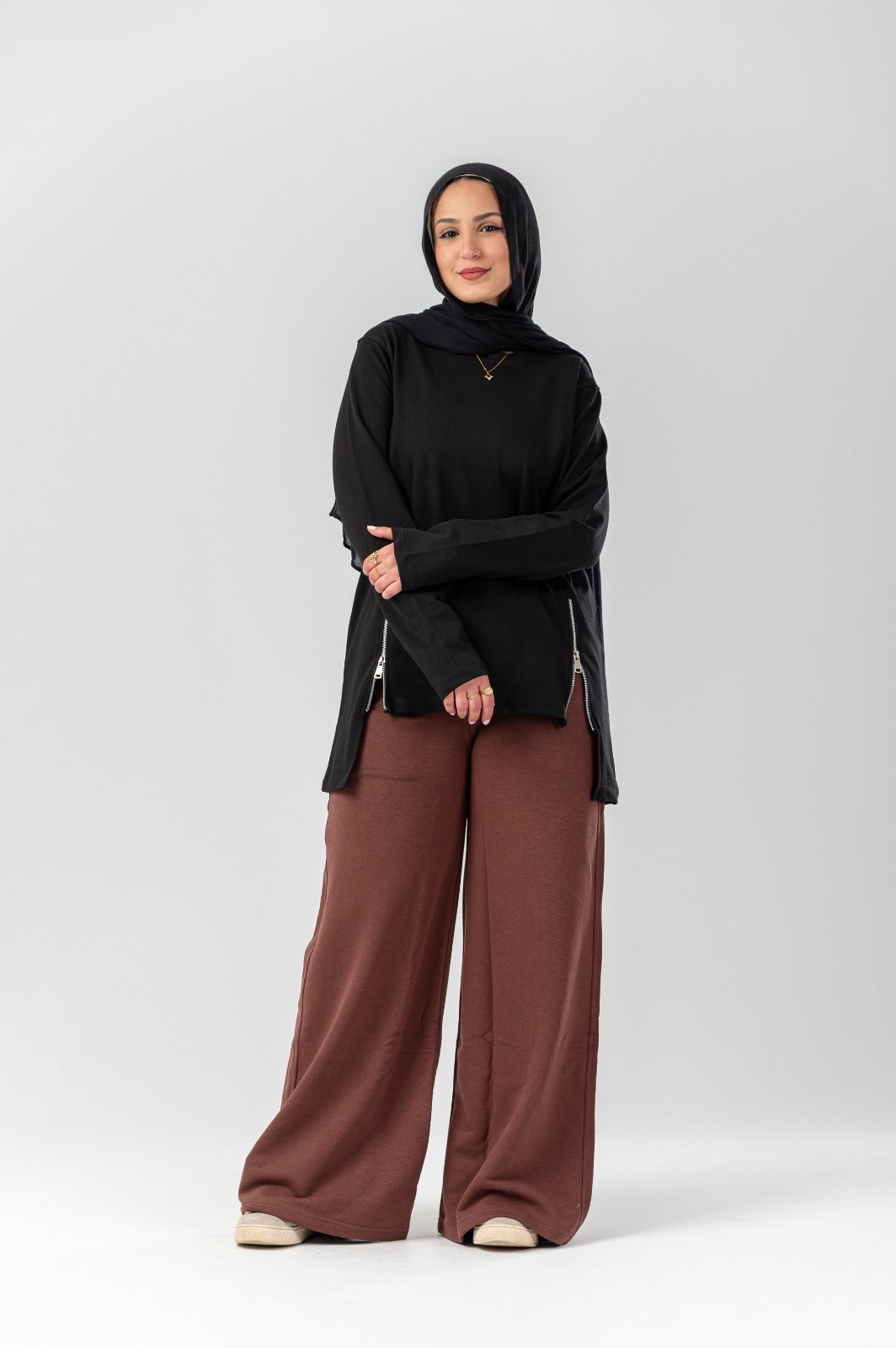 Black Akira side-zip longline T-shirt with a relaxed fit and extended hem, front view showing zipper detail and soft fabric.