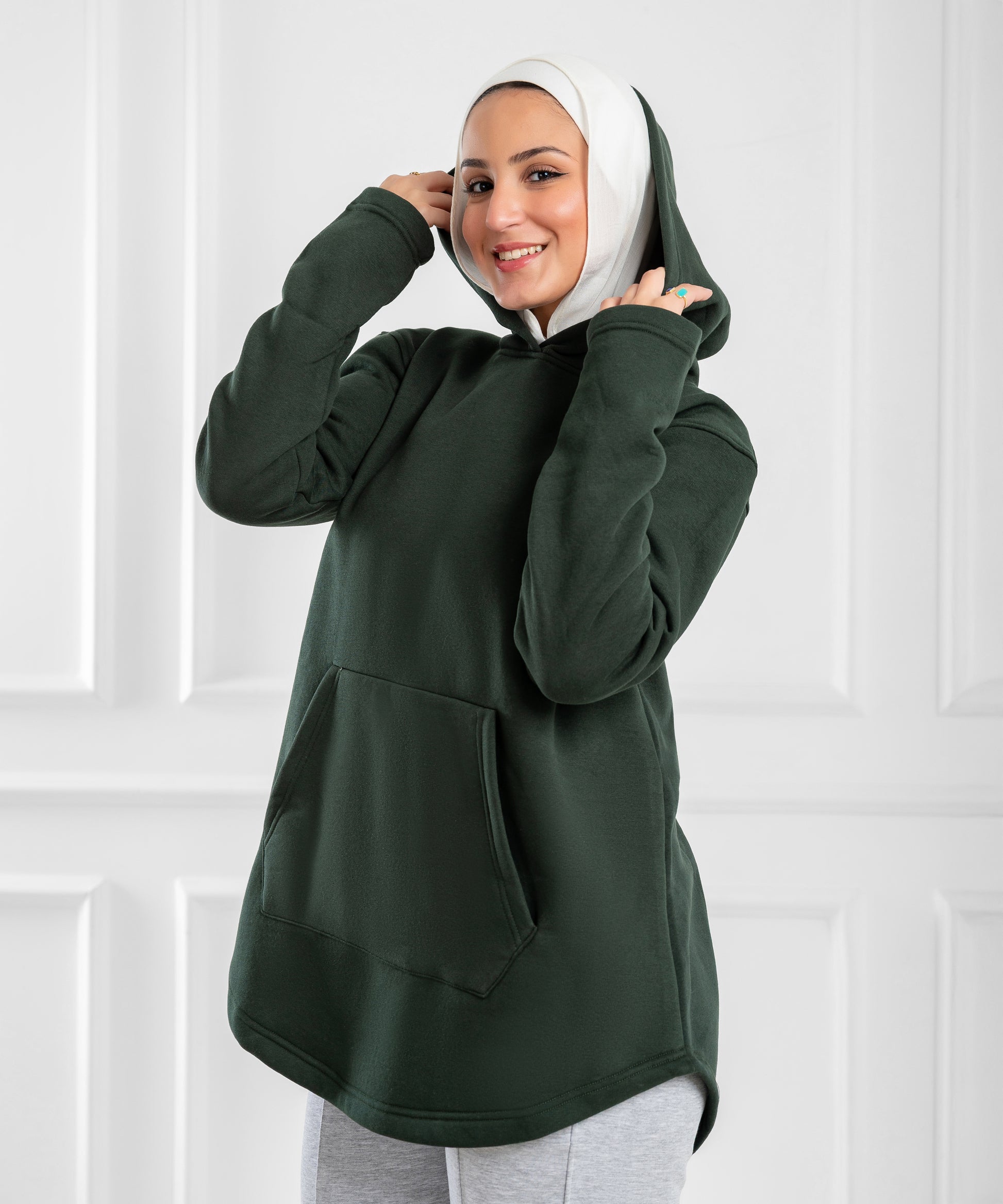 Akira curved-hem fleece tunic hoodie with long sleeves and relaxed fit, shown in soft fabric on a neutral background.