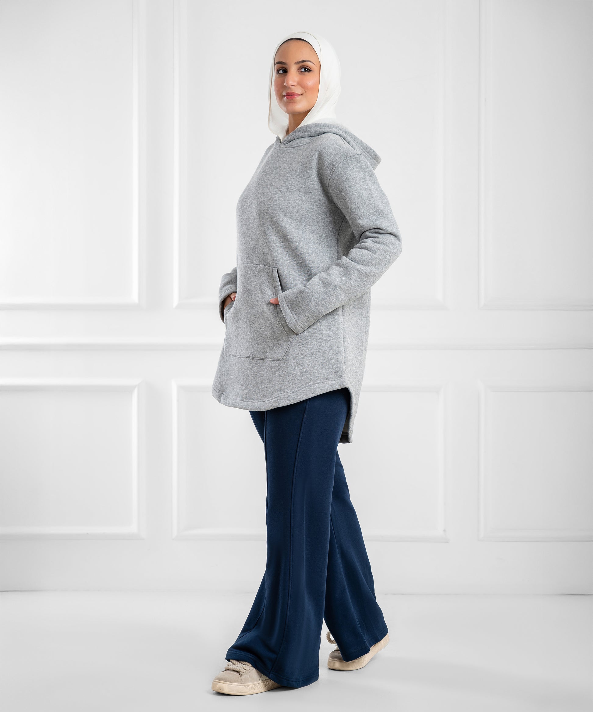 Akira curved-hem fleece tunic hoodie displayed on a hanger, showcasing its cozy fabric and stylish, relaxed fit.