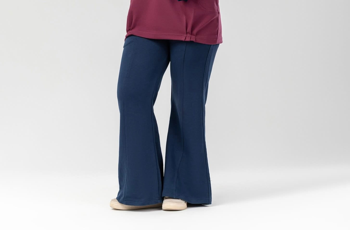Blue flare pants by Akira, full-length view showing wide-leg design and vibrant fabric detail.