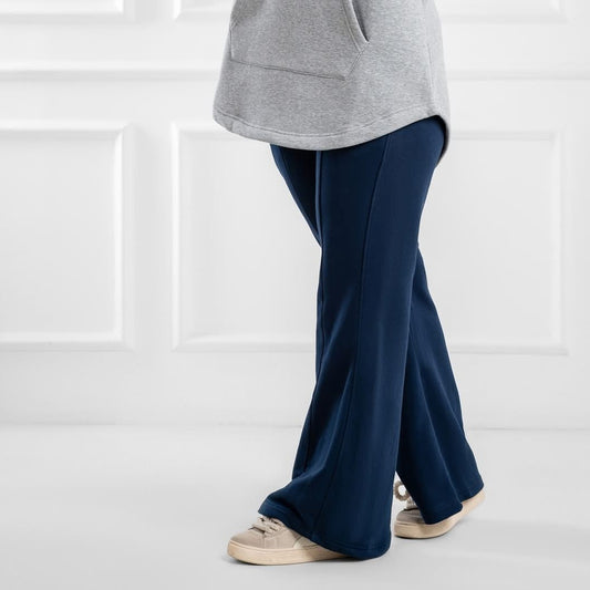 Blue flare pants from Akira featuring high-waisted design and wide-leg style, shown on a model with a casual outfit.