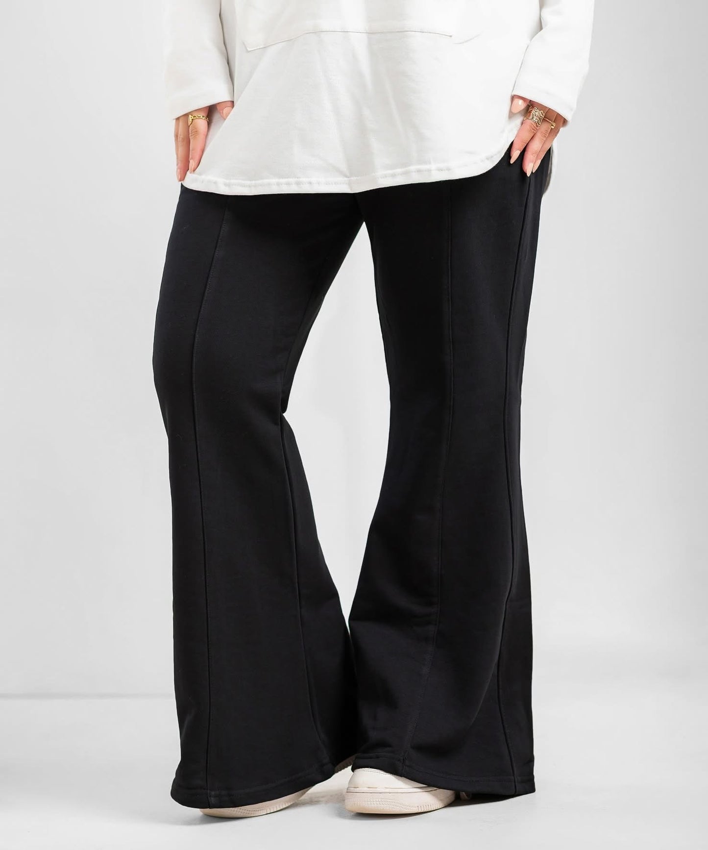 Black flare pants from Akira, showcasing their high-waisted fit and wide-leg design on a model.