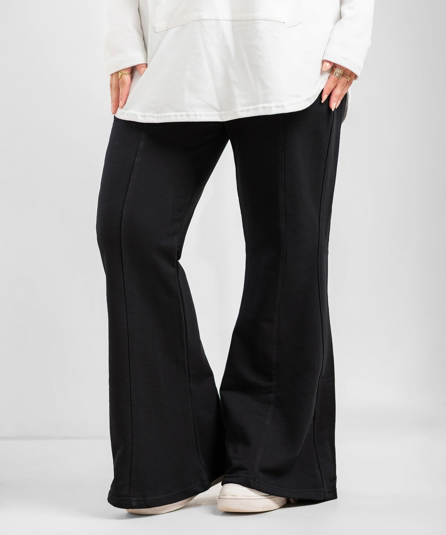 Black flare pants from Akira, showcasing their high-waisted fit and wide-leg design on a model.