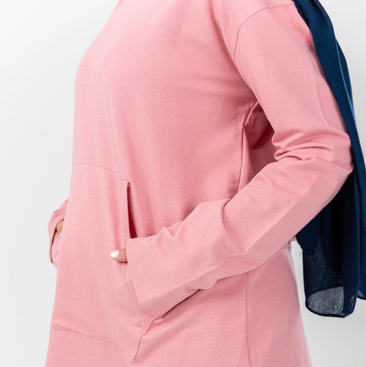 Pink hoodie by Akira featuring a comfortable fit and casual style, shown on a hanger with a soft fabric texture.